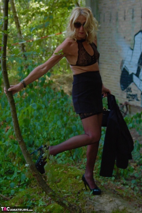 Зрелая блондинка Кирас Нейлонс позирует на шпильках в чулочно-носочных изделиях и черной юбке 18