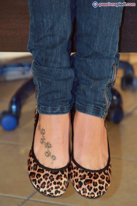 Одинокая девушка в джинсах и куртке освобождает босые ноги от туфель на плоской подошве 2