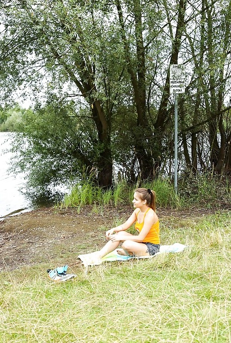 Грудастая молоденькая любительница Адель раздевается догола в лесу, чтобы искупаться в озере 1