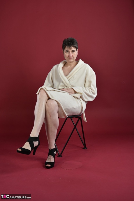 Горячая мамаша-любительская модель освобождает свои ноги от каблуков, прежде чем расстегнуть халат 1
