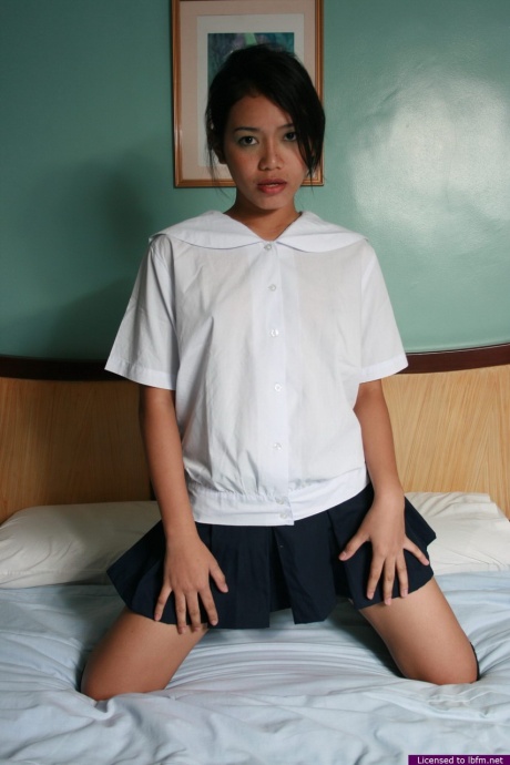 Горячая азиатская школьница снимает свою униформу, чтобы потереться своей лысой киской о кровать 1
