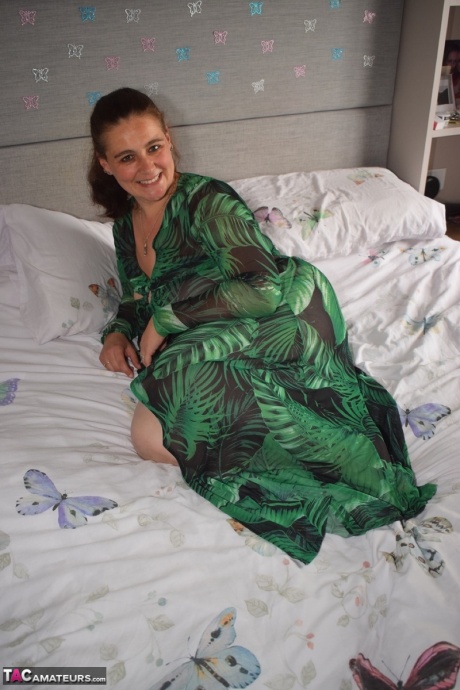 Толстая женщина обнажает себя на кровати в длинном платье 10