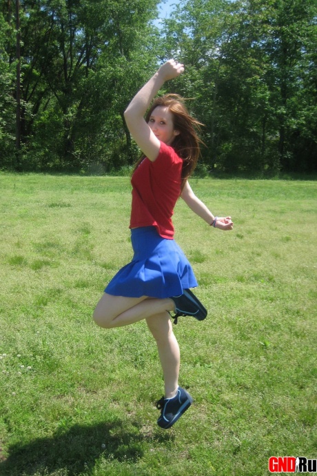 Молодо выглядящая рыжеволосая красотка демонстрирует свои сиськи и нижнее белье на футбольном поле 4