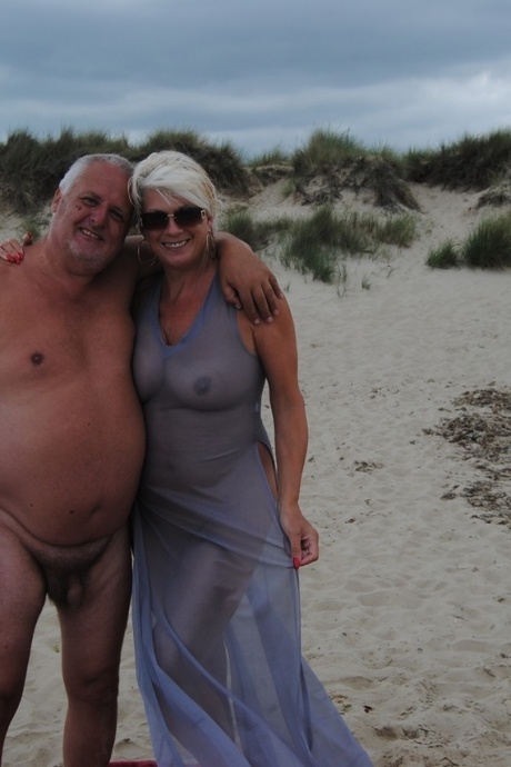 Пожилая платиновая блондинка Димонти посылает воздушный поцелуй на нудистском пляже со своим мужчиной 1