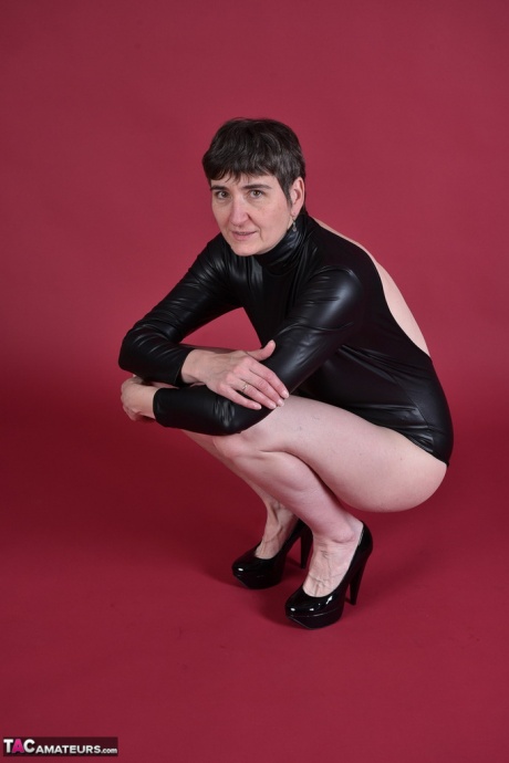 Коротко стриженная брюнетка постарше показывает свою лысую киску, моделируя полностью обнаженной 1