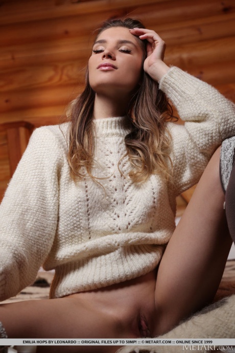 Великолепная молоденькая Эмилия Хопс снимает большой свитер, чтобы позировать обнаженной в чулочно-носочных изделиях OTK 3