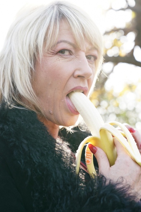 Зрелая блондинка съедает банан перед групповухой в сельской местности 9