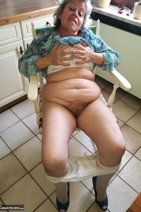 Возбужденная бабуля Каро засовывает банан в свою натуральную киску на кухонном стуле 1