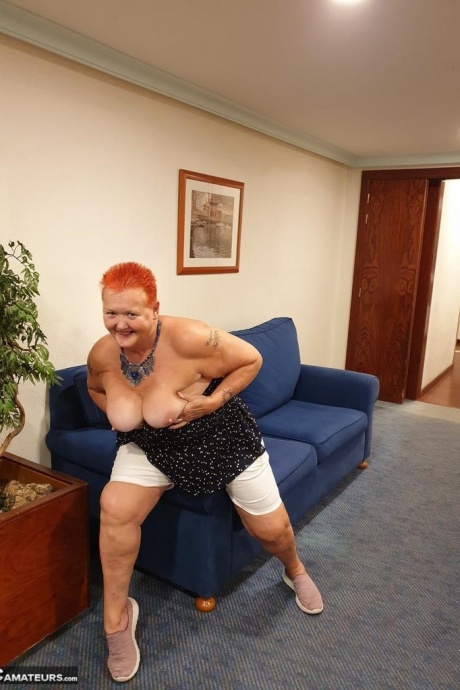 Толстая бабуля с короткими рыжими волосами прижимается своими большими сиськами и задницей к стеклу 20