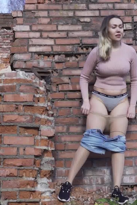 Белая девушка прячется за старым зданием, чтобы срочно отлить 12