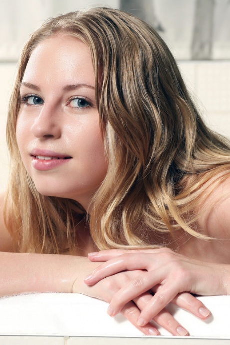 Милая молодая девушка Ева принимает ванну с пеной в игривой манере 13