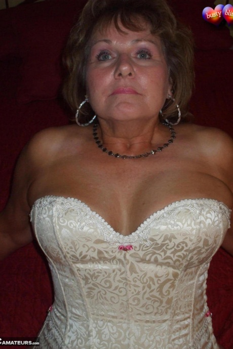 Зрелая женщина позирует обнаженной в корсете и нейлоновых чулках с подвязками 9