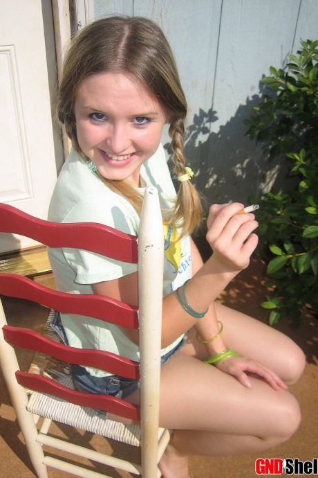 Молодая девушка курит сигарету, обнажая свои сиськи и киску 7