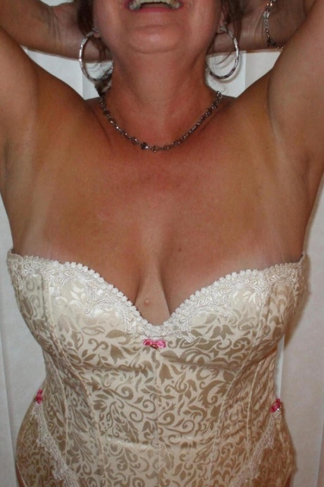 Зрелая женщина позирует обнаженной в корсете и нейлоновых чулках с подвязками 14