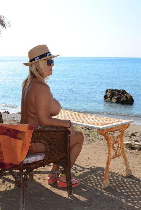 Толстая блондинка с большими сиськами бродит по нудистскому пляжу в соломенной шляпе 17