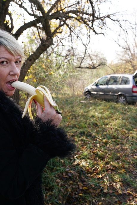 Зрелая блондинка съедает банан перед групповухой в сельской местности 10