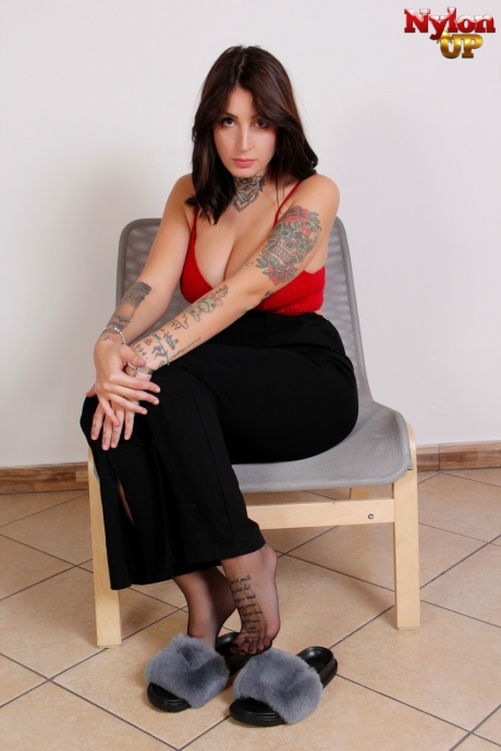 Грудастая брюнетка красотка Токио освобождает свои обтянутые колготками ножки от тапочек 1