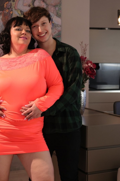 Пожилая брюнетка толстушки Эллен Сент занимается сексом со своим игрушечным мальчиком на диване 1