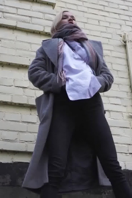 Белокурая девушка Маша стягивает штаны, чтобы пописать на тротуаре в дождливый день 14