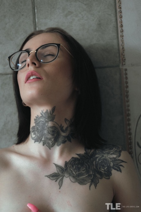 Потрясающая татуированная брюнетка Полли Стар стоит обнаженная в своей ванне, облизывая губы