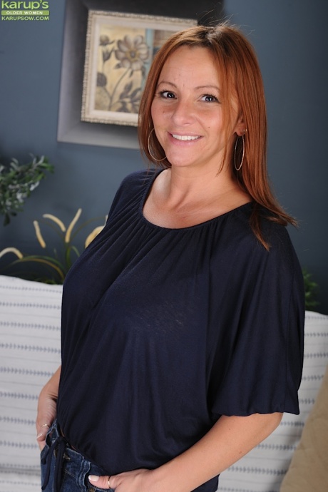 Зрелая рыжеволосая Джиа София дразнит свои большие сиськи и задницу, раздеваясь